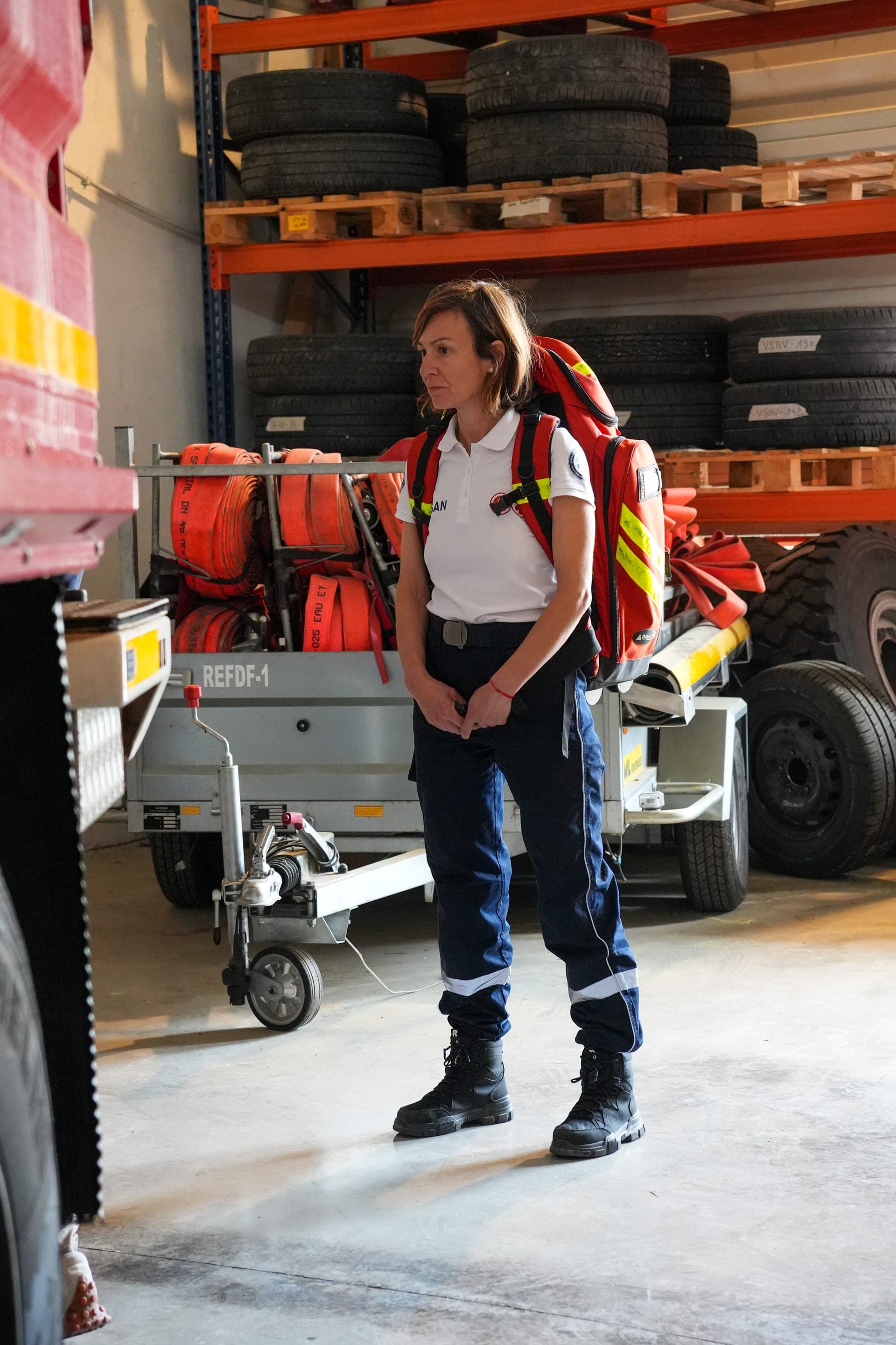 Bénévole OPSAN équipée d'un sac de premier secours dans une halle technique