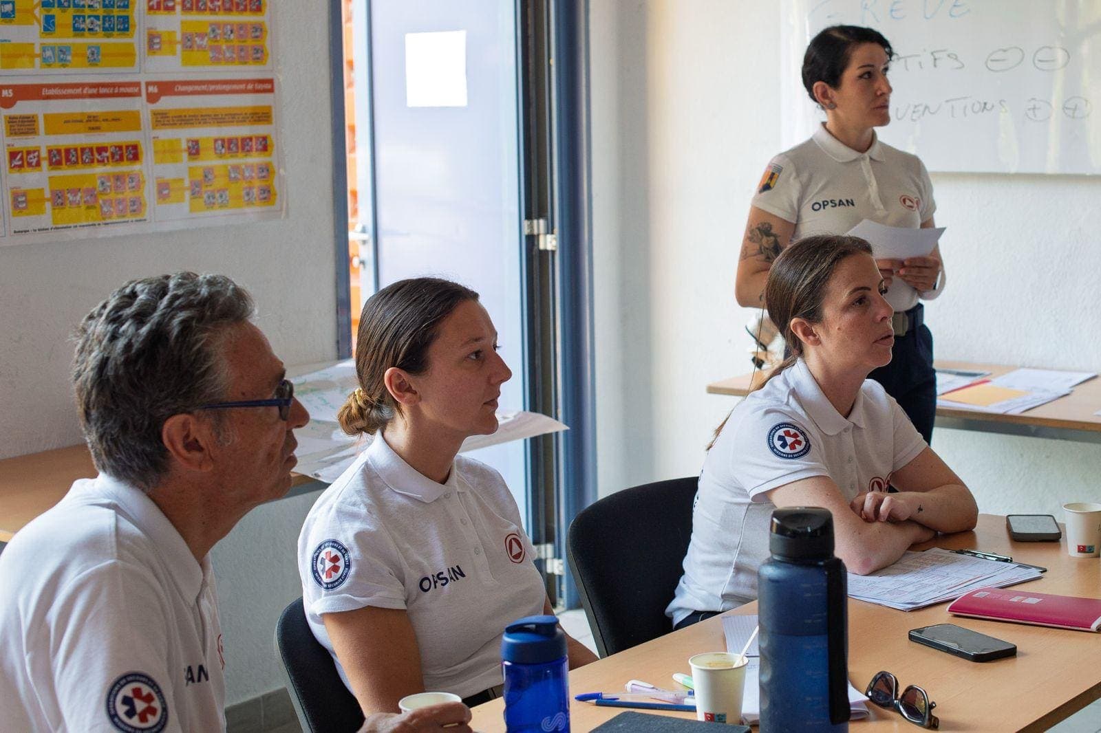 Secouristes OPSAN en polo attentifs pendant une session de formation en salle